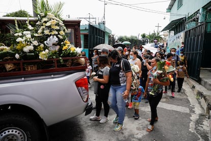 Familiares, amigos y vecinos del poblado de Ciudad Delgado, al norte de San Salvador, caminan detrás de los coches fúnebres que trasladan los restos de César Vladimir Antillón, de 36 años, y su hijo Matthew Alexander Antillón Orellana, de siete, el 26 de mayo de 2022.