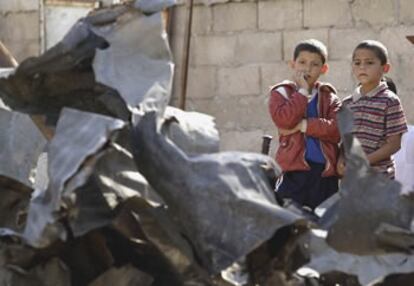 Dos niños palestinos miran los restos de un fusil en Gaza.