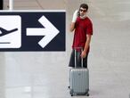 A passenger wearing a protective face mask waits for his flight at Fiumicino Airport, one of the two airports in the world to obtain the 'Biosafety Trust certification' for the correct application of security measures to prevent infections, following the coronavirus disease (COVID-19) outbreak, in Rome, Italy June 30, 2020. REUTERS/Guglielmo Mangiapane