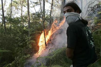 Un vecino de Rexenxo, en el <i>concello</i> de Valga (Pontevedra), colabora en la extinción de un fuego.