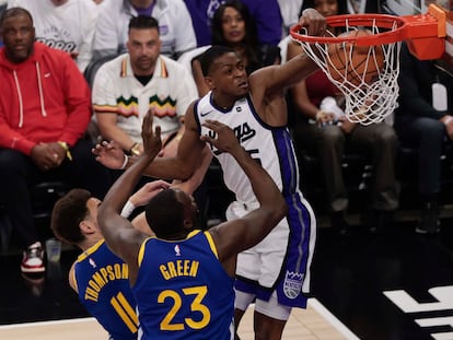 De'Aaron Fox, de los Sacramento Kings, hace un mate frente a Thompson y Green, de Golden State.