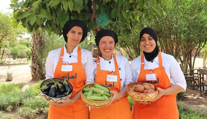 Tres de las estudiantes de la escuela de cocina posan con productos que luego cocinarán. 