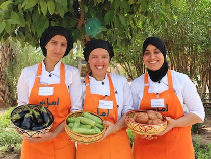 Tres de las estudiantes de la escuela de cocina posan con productos que luego cocinarán. 