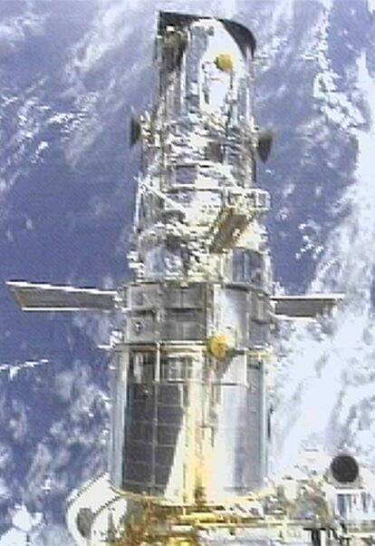 El <i>Hubble,</i> sujeto al transbordador para su mantenimiento, en 2002.
