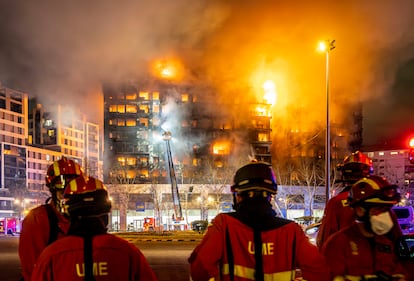 Un grupo de bomberos, ante el edificio incendiado en Valencia.