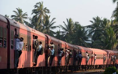 Un grupo de viajeros se aferra a los laterales de un tren mientras se dirigen a trabajar a Colombo (Sri Lanka).