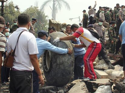 Al menos 30 personas han muerto tras estrellarse un avión de transporte 'Hércules' de la Fuerza Aérea indonesia contra un hotel en una zona residencial en la localidad de Medan, en el norte de la isla de Sumatra. En la imagen, personal de rescate retiran restos del avión tras el accidente, el 30 de junio de 2015.