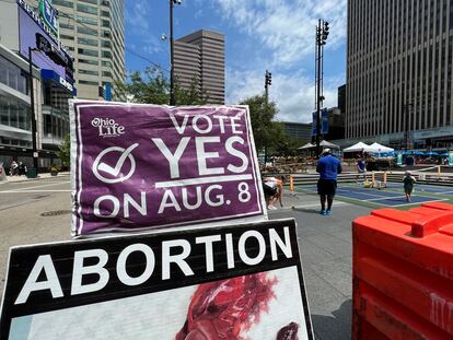 A sign asking Ohioans to vote in support of Issue 1 sits above another sign advocating against abortion rights