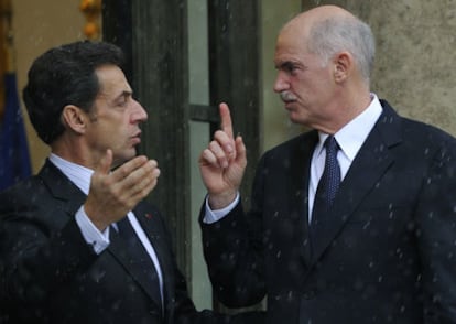 El presidente de Francia, Nicolas Sarkozy, junto al primer ministro griego, George Papandreu, bajo la lluvia en París.