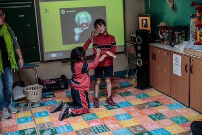 Dos alumnos de primaria hablan en lengua de signos durante la clase con la monitora especial.