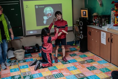 Dos alumnos de primaria hablan en lengua de signos durante la clase con la monitora especial. 