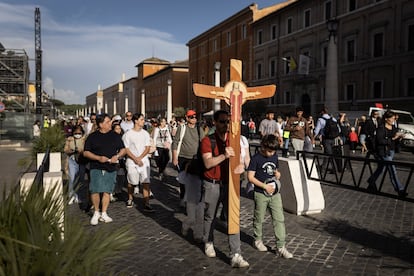 Un grupo de feligreses se acerca a la plaza de San Pedro, portando una gran cruz.