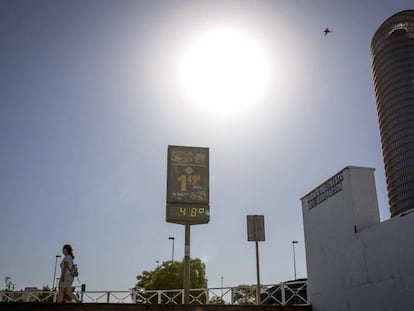 Una mujer pasa junto a un termómetro que marca 48º al sol frente a Torre Sevilla, el pasado 18 de junio.