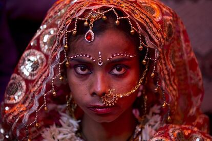 Seema, una niña india, espera a que su novio llegue durante una ceremonia de matrimonio masivo en Nueva Delhi, India. Doce parejas de familias pobres se han casado en una ceremonia única que, de lo contrario, habría costado a cada familia miles de dólares.