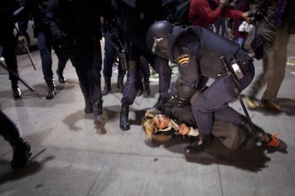 Un policía reduce a una manifestante durante la protesta en Madrid.
