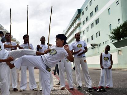 Crianças jogam capoeira