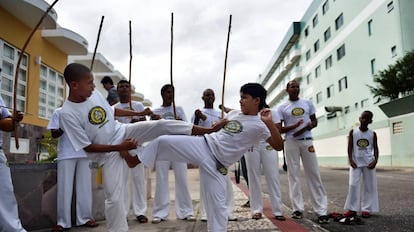 Crianças jogam capoeira