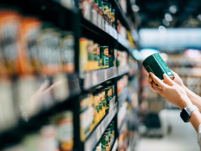 Una persona lee la etiqueta de un producto en un supermercado.