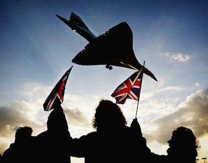 Unos cuantos espectadores agitan banderas británicas en el aeropuerto de Heathrow (Londres) el 24 de octubre de 2003 cuando el Concorde toma tierra en su último vuelo.