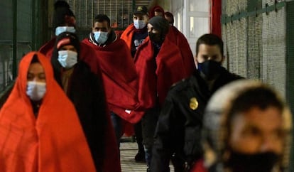 Miembros de Salvamento Marítimo y de la Policía Nacional trasladan al puerto de Almería a los tripulantes de una patera, este miércoles.