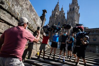 Un grupo de peregrinos haciéndose una foto con la catedral de Santiago al fondo.
