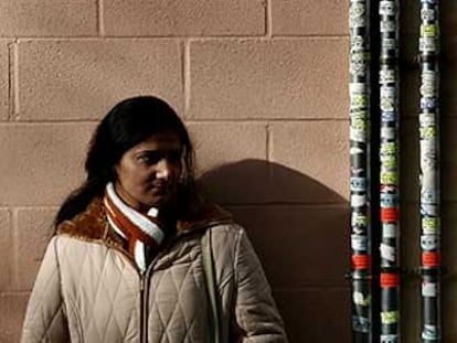 Los inmigrantes suman el 16,3% de la población de Orriols. Una de ellas espera junto a montones de ofertas de servicios.