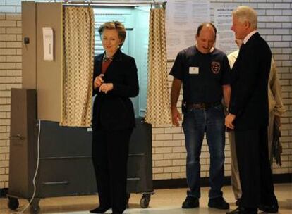 Hillary y Bill Clinton, bromean con un policía en su colegio electoral, en Nueva York.