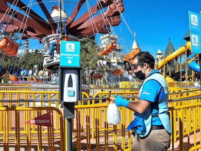 A staff member disinfects the gates to an attraction during reopening day at Six Flags Mexico on October 23, 2020 in Mexico City, Mexico.