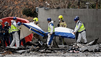 Agentes de la policía científica retiran con una camilla un cuerpo hallado esta mañana en el edificio incendiado en Valencia.