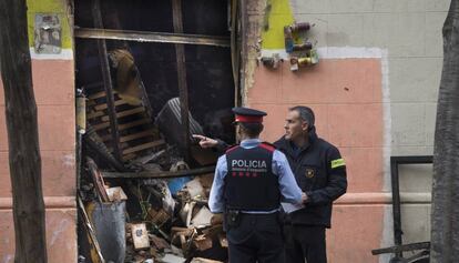 Agentes de policía observan el estado en que ha quedado el edificio tras el incendio.