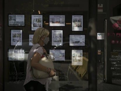 Una dona passa per una agència immobiliària a l'Eixample.