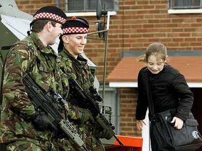 Un niña católica juega delante de dos soldados británicos en la zona norte de Belfast en noviembre de 2001.