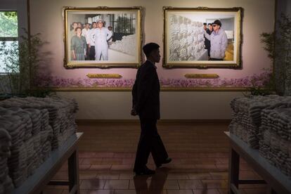 Un guía camina entre los retratos de los líderes de Corea del Norte Kim Il-Sung y Kim Jong-Il.