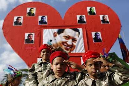 Niños vestidos de militares saludan ante una foto de Hugo Chávez, durante el carnaval celebrado en Caracas el 4 de marzo de 2014, previo a los actos conmemorativos del primer aniversario de la muerte del comandante.