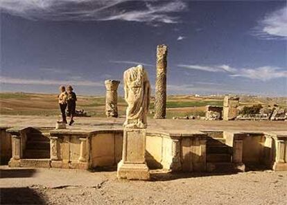 Dos visitantes del parque arqueológico de Segóbriga (Cuenca), sobre el escenario del teatro romano, del siglo I. En verano se celebran representaciones de teatro.