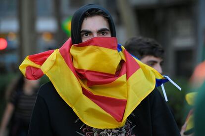 Un manifestante cubre su cara con una bandera en el centro de Barcelona.