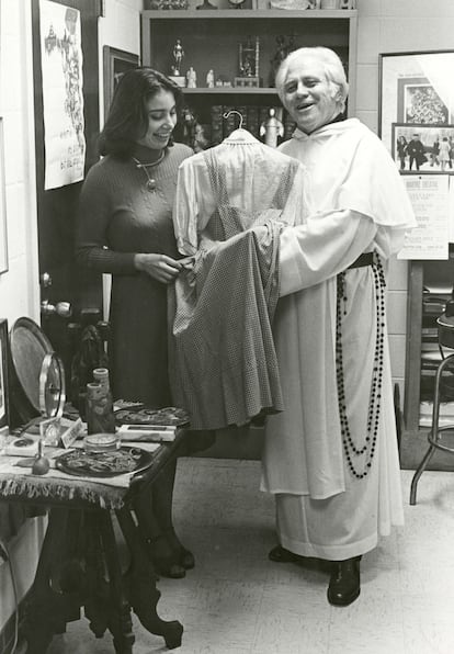 Una fotografía divulgada por la Universidad Católica de América donde aparece el padre Gilbert Hartke y la estudiante Carol Pearson mientras sostienen el vestido de Dorothy en 'El mago de Oz' de 1939.