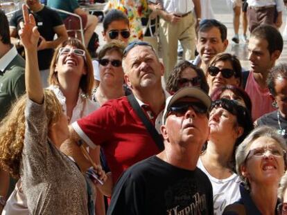 Cruceristas llegados a Valencia escuchan a una gu&iacute;a bajo la catedral de Valencia.