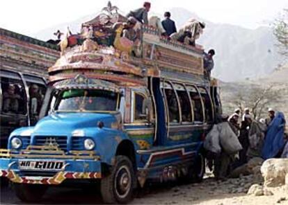 Familias afganas recién llegadas de Kabul suben a un autobús cerca de Peshawar (Pakistán).