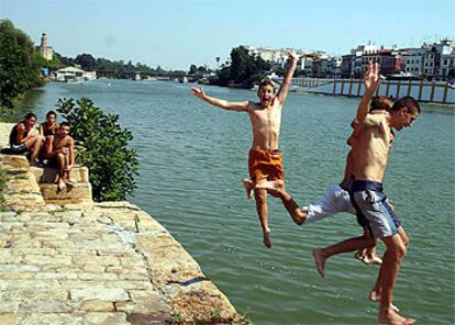 Un grupo de jóvenes se baña ayer en el Guadalquivir en Sevilla.