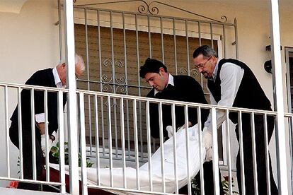 Operarios de la funeraria retiran el cuerpo del agresor que, tras matar a su esposa en Calpe, se suicidó.