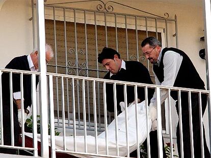 Operarios de la funeraria retiran el cuerpo del agresor que, tras matar a su esposa en Calpe, se suicidó.