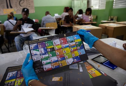 Un funcionario sostiene una papeleta electoral en la escuela República de Chile, que es utilizada como centro de votación.