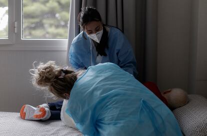 Dos mujeres atienden a un paciente durante la pandemia.