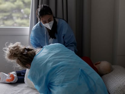 Dos mujeres atienden a un paciente durante la pandemia.