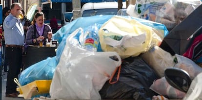 Vecinos de Sevilla, junto a la basura acumulada por el quinto día de huelga de los trabajadores de la empresa municipal de limpieza (Lipasam).
