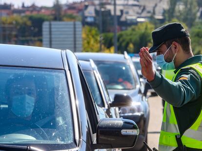 Un agente de la Guardia Civil da el alto a un vehículo durante un control en Madrid, el pasado 10 de octubre, después de que el Consejo de Ministros declarase el estado de alarma en esa región.