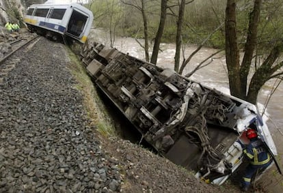 Un bombero supervisa uno de los vagones de un tren descarrilado.