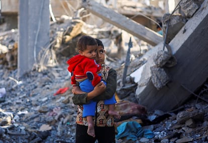 Un niño y un bebé, entre los escombros de los edificios destruidos por los ataques israelíes, este lunes en Rafah. 