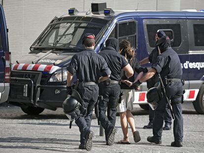 Cuatro <i>mossos</i> conducen detenido a un miembro del 15-M.